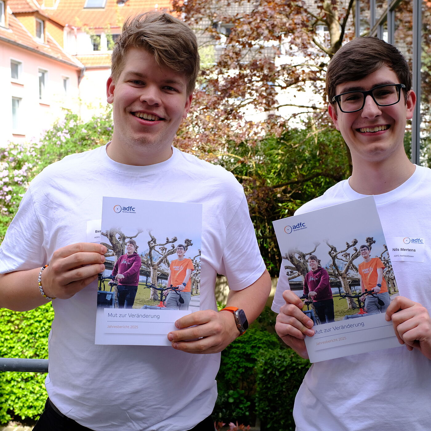 2026_04_18_Landesversammlung_Muenster_ADFC-NRW zwei Personen halten einen Bericht hoch.