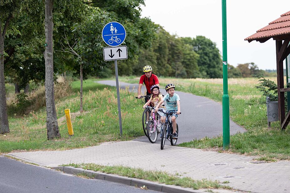 Radfahren mit den Enkelkindern Opa mit Enkelkindern auf Radweg
